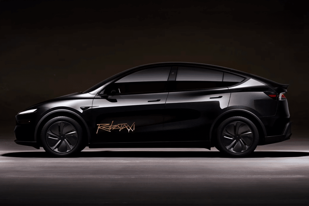 A sleek black electric SUV with tinted windows and a bold gold "REKTAN" logo on the driver’s door, parked in a dimly lit space—evoking the futuristic vibe of a Waymo vs Tesla robotaxi showdown.