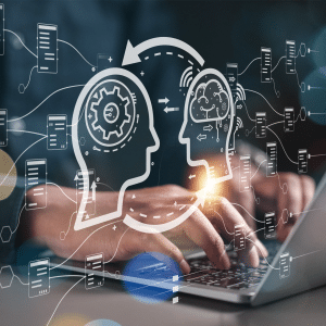 A person types on a laptop with a digital overlay showing two head profiles—one with gears, the other with a brain—connected by arrows and data flow, symbolizing artificial intelligence, data exchange, and the evolving computer science graduates job market.