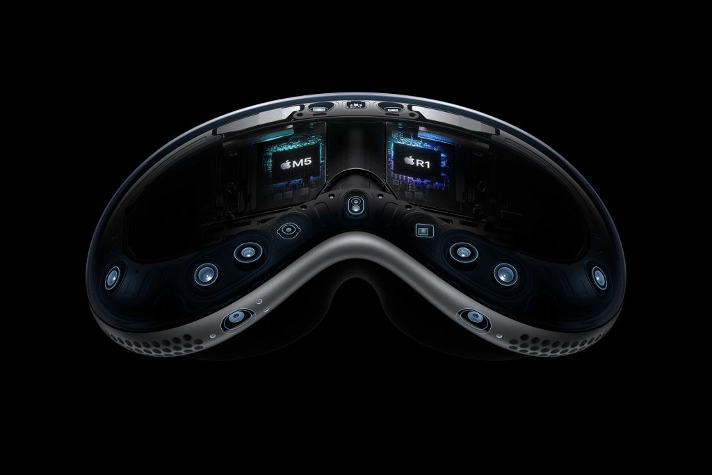 Close-up view of the inside of the Apple Vision Pro headset, showing multiple cameras, sensors, and visible Apple M2, R1, and Vision Pro M5 chips—all set against a black background.