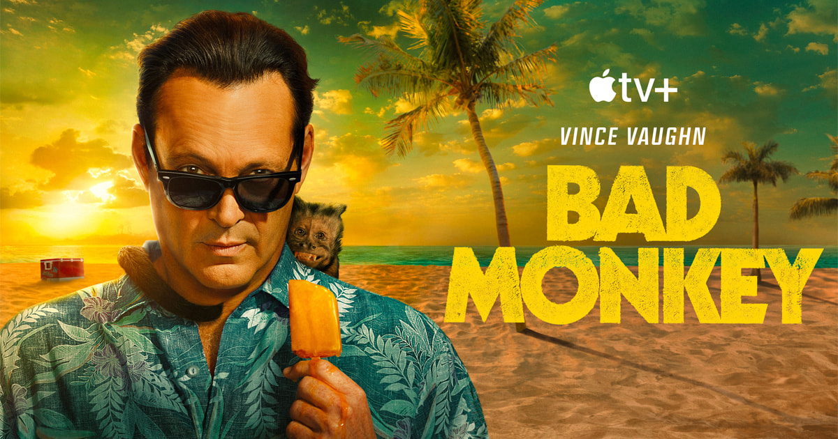 A man in sunglasses and a tropical shirt holds a popsicle on the beach at sunset, with a small monkey on his shoulder. Palm trees and a cooler are in the background. Text: "Apple TV+, Vince Vaughn, Bad Monkey Season 2.