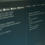 Close-up of a computer screen displaying lines of programming code in a dark-themed editor, with syntax and logic structures visible—some relating to AI and personal data sharing—split across the window, parts slightly out of focus.