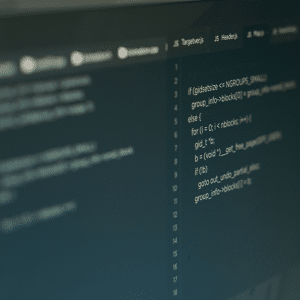 Close-up of a computer screen displaying lines of programming code in a dark-themed editor, with syntax and logic structures visible—some relating to AI and personal data sharing—split across the window, parts slightly out of focus.