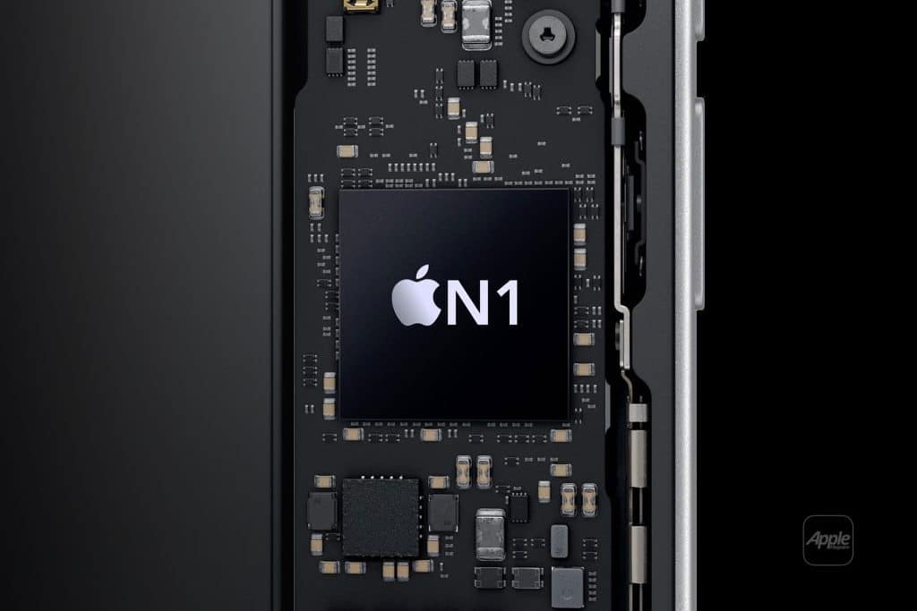 Close-up of a circuit board inside an electronic device, featuring a large black chip labeled with the Apple logo and "N1" in white text—identifying it as the Apple N1 wireless processor. Various electronic components surround the central chip.