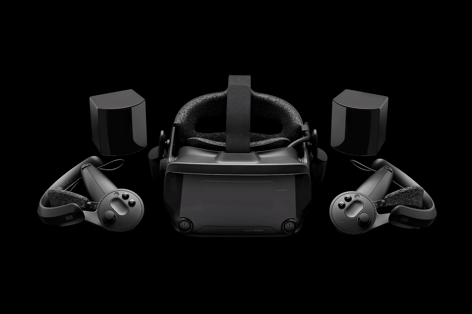 A Valve new VR headset with two hand controllers and two base stations is displayed on a black background. The devices are arranged symmetrically, showcasing all components of the advanced VR system.