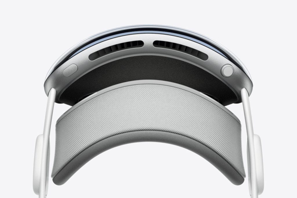 Close-up view of a modern virtual reality headset from above, featuring a curved headband, cushioned padding, ventilation slots, and adjustable side supports—perfectly suited for Apple immersive video production with its sleek, minimalist white and gray design.