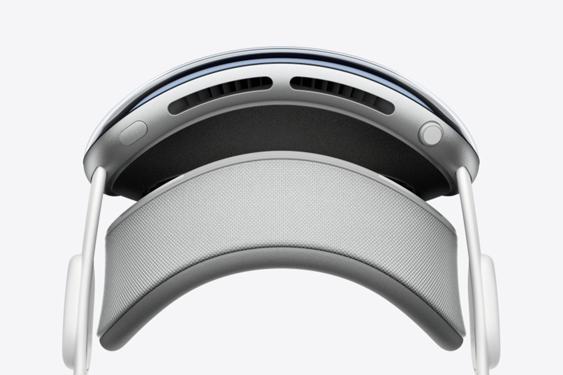 Close-up view of a modern virtual reality headset from above, featuring a curved headband, cushioned padding, ventilation slots, and adjustable side supports—perfectly suited for Apple immersive video production with its sleek, minimalist white and gray design.