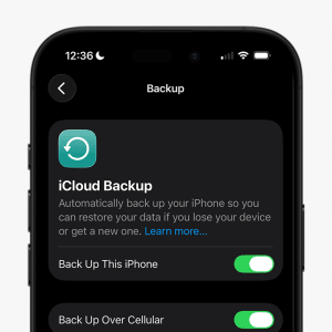 A smartphone screen displays the iCloud Backup settings, both options toggled on. Perfect for an iPhone backup guide, it shows how to back up your iPhone and use cellular data. The time is 12:36, and the device is charging.