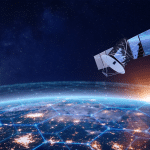 A satellite orbits above Earth at sunrise, with illuminated cities visible below and a glowing hexagonal network pattern overlaying the planet’s surface, symbolizing global connectivity powered by data centers in orbit.