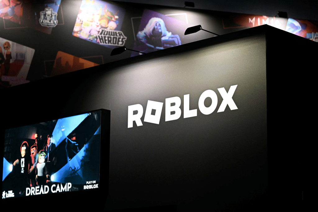 A large black display features the ROBLOX logo in white letters. Below, a screen shows the game "Dread Camp" with animated characters—highlighting ROBLOX’s popularity even amid Russia internet restrictions. Posters of other games are partially visible in the background.