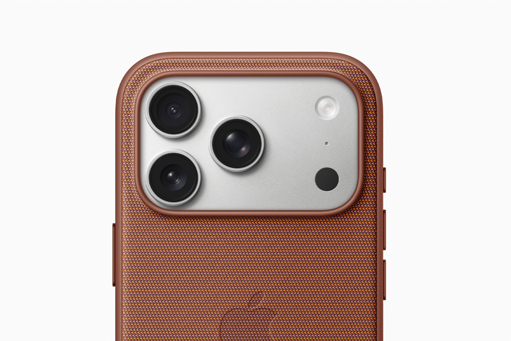 Close-up of the back of an Apple phone, featuring three camera lenses and a flash, encased in a textured brown Apple phone case. The Apple logo is faintly visible on the case.
