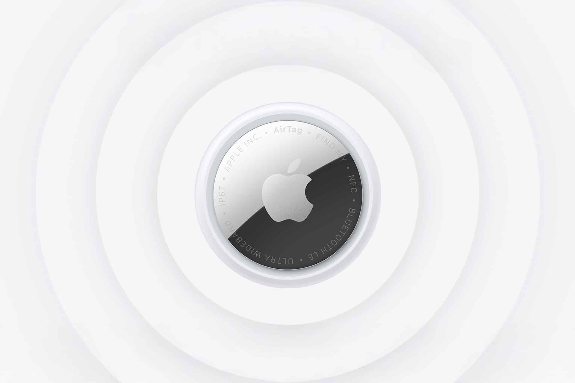 A close-up view of the new AirTag placed at the center of concentric white circles, highlighting the device's metallic surface and engraved Apple logo.