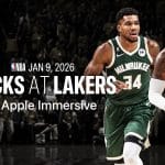 Two basketball players from the Milwaukee Bucks and Los Angeles Lakers run on a court. Text reads: "NBA Jan 9, 2026 Bucks at Lakers in Apple Immersive." Experience Vision Pro NBA Games as the crowd cheers in a dimly lit arena.