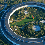 Aerial view of a large, circular building surrounded by trees and greenery, with a rainbow-colored structure in the courtyard—an iconic site often linked to major Apple Acquisitions and innovative apple takeovers shaping the tech landscape.