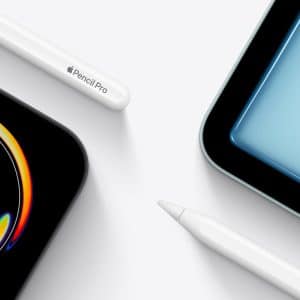 Two iPad tablets with vibrant screens are displayed at the corners, paired with two white styluses—one labeled "Apple Pencil Pro"—on a white background. The scene evokes a creative vibe inspired by Apple Creative Studio.