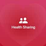 White "Health Sharing" text with two user icons above it is centered on a red-pink background with a large faint heart shape. An Apple logo appears in the bottom right corner, highlighting iPhone emergency contacts integration.