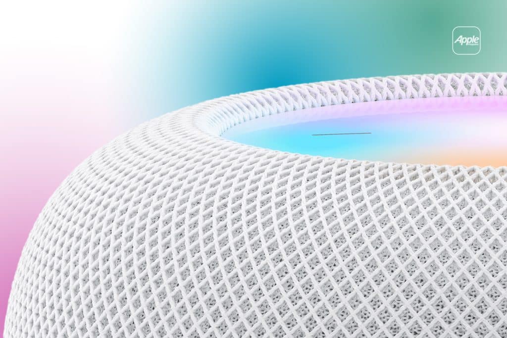 HomePod - Close-up of a white mesh-textured HomePod smart speaker with a glowing, multicolored top surface; a blurred gradient background and an Apple logo appear in the upper right corner.