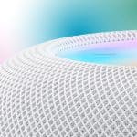 HomePod - Close-up of a white mesh-textured HomePod smart speaker with a glowing, multicolored top surface; a blurred gradient background and an Apple logo appear in the upper right corner.