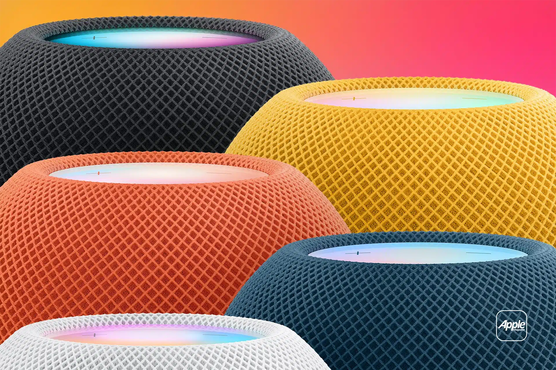 Several colorful Apple HomePod Mini smart speakers in black, yellow, orange, blue, and white are shown close together against a pink and orange gradient background, highlighting the HomePod Intercom feature. The Apple logo sits in the corner.