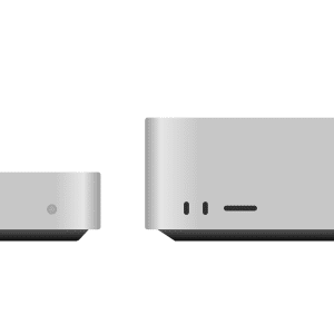 Two silver, rectangular desktop computer units are shown side by side against a white background, illustrating the size difference in the Mac Mini vs. Mac Studio comparison: the left unit is shorter and slimmer, while the right is taller and larger.
