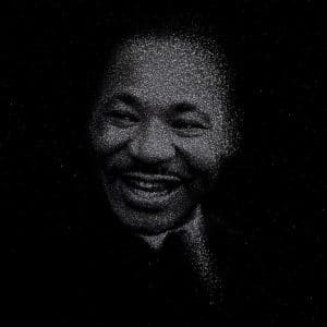 A portrait of Martin Luther King, smiling and created using many small white dots against a black background, giving a starry or pointillist effect.