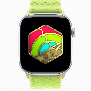An Apple Watch with a yellow-green band displays a colorful hexagonal design featuring gold, pink, red, and green elements, with "2026" in gold at the bottom center—perfect for fitness motivation and style.