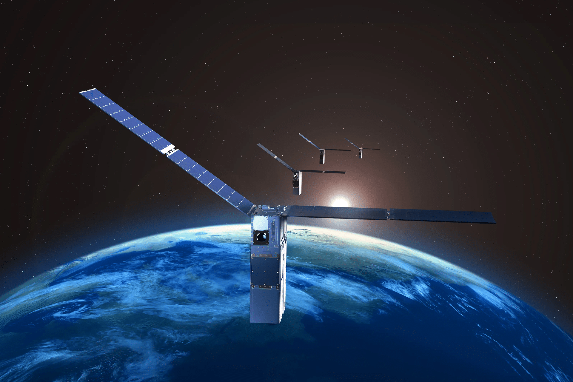 A group of small Apple Starlink satellites with solar panels orbits above Earth’s blue surface, as the sun rises in the background against the darkness of space.