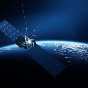 A Starlink In Flight satellite with large solar panels orbits above the Earth, its blue surface and swirling clouds framed by the dark expanse of space in the background.
