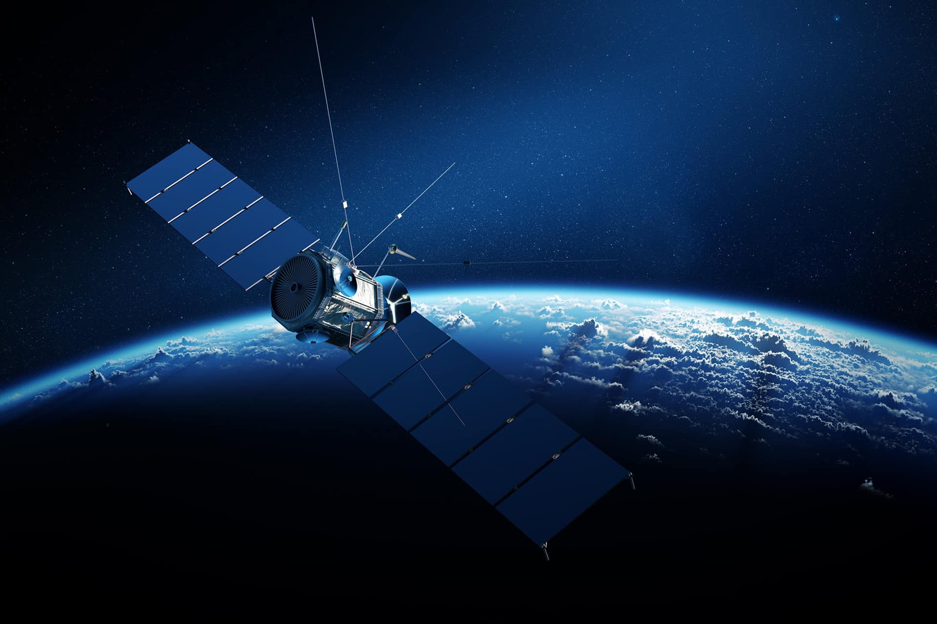 A Starlink In Flight satellite with large solar panels orbits above the Earth, its blue surface and swirling clouds framed by the dark expanse of space in the background.