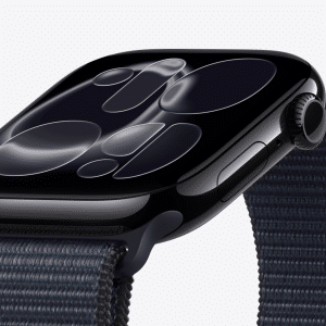 A close-up of a black smartwatch with a dark reflective screen displaying abstract, circular patterns, attached to a textured dark fabric strap, shown against a plain light background—perfect for showcasing Apple Watch screen care.