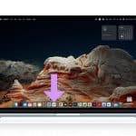 A laptop displays a scenic desert landscape as its wallpaper. A large purple arrow points to the center of the dock, highlighting Web Apps at the bottom of the screen. The Apple logo appears in the top right corner.