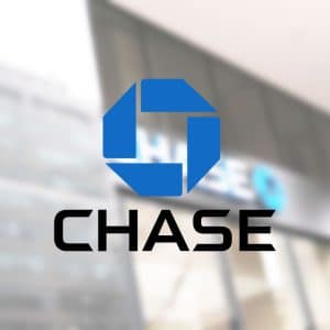 Chase bank logo in blue and black, centered over a blurred building exterior; an "Apple Card" logo is faintly visible in the lower right corner.