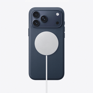 A dark blue iPhone 17 with three rear cameras is connected to a circular wireless charger attached to its back. The white charger, cable extending downward, powers up the device while addressing static speaker noise issues.