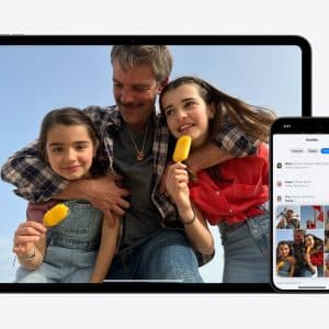 A man hugs two smiling girls holding yellow ice pops, displayed on a tablet screen. Next to it, a smartphone shows a photo-sharing app synced with iCloud, featuring pictures of the same group.