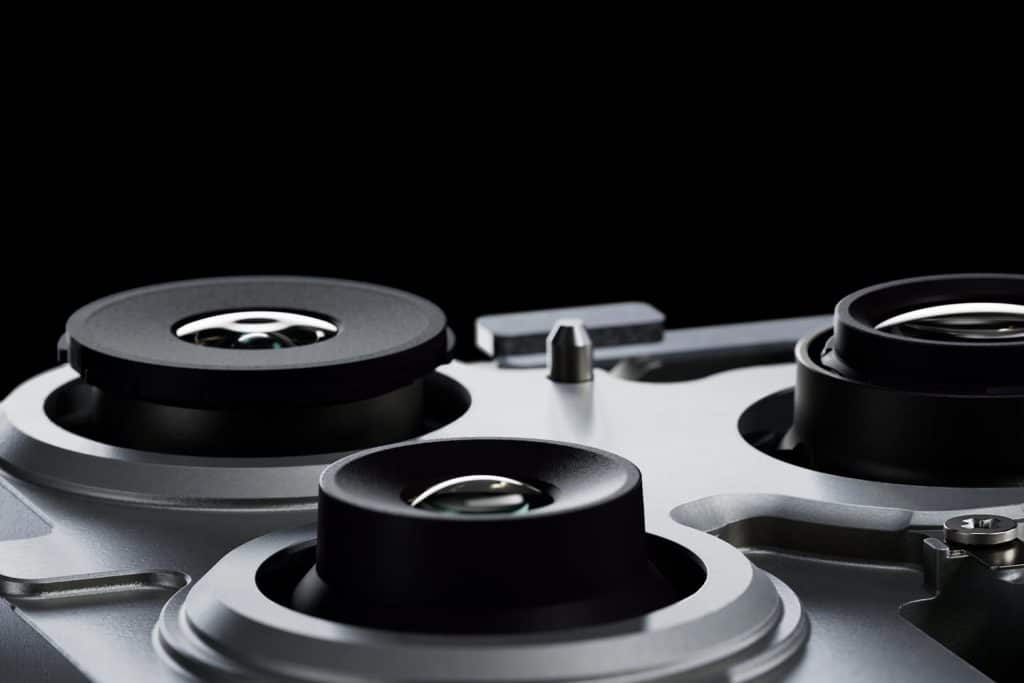 iPhone Macro Camera - Close-up of three camera lenses on a silver smartphone, set against a black background. The image highlights the lens details and metallic finish of the iPhone 200Mp Camera module.