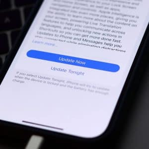A smartphone screen displays an iOS update prompt with options to "Update Now" or "Update Tonight," while the device is charging—helpful for troubleshooting when your iPhone won’t update.