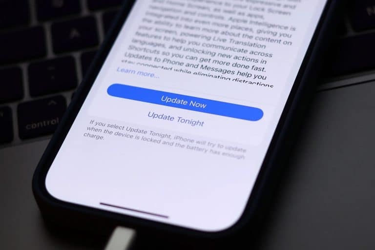 A smartphone screen displays an iOS update prompt with options to "Update Now" or "Update Tonight," while the device is charging—helpful for troubleshooting when your iPhone won’t update.