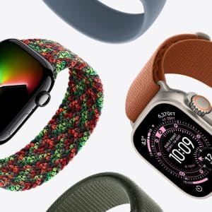 Two smartwatches with colorful loop bands are displayed on a white background; one features a black face with a minimal display and red-green band, while the other, perfect for pairing with an Apple Watch Band Skin Tone, shows a digital interface and an orange band.