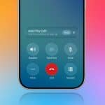 A smartphone screen displays an active call with options like speaker, FaceTime, mute, more, end, and keypad. A colorful gradient background is visible as a Hold Assist Detection notification says, “Hold This Call? You’ll be notified to pick up.”.