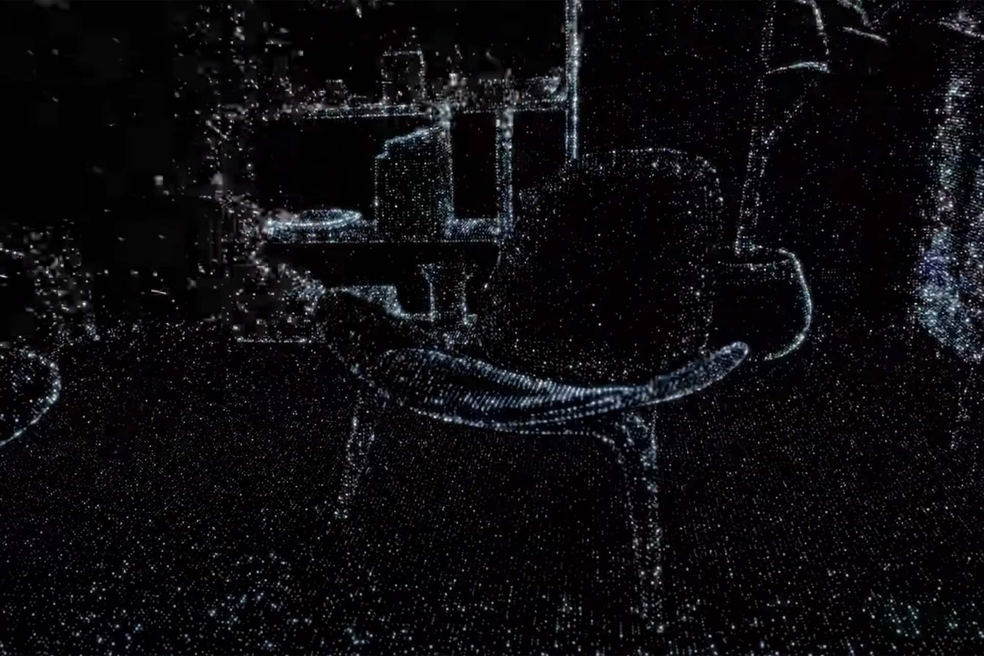 A chair is visible in the foreground of a dark room, depicted in a pointillist or dot-matrix style reminiscent of an iPhone LiDAR scan. Shelves and objects can be faintly seen in the background, all outlined with glowing white dots.