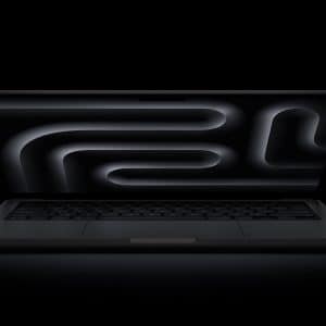 A sleek black MacBook Pro OLED is open on a dark surface, its screen displaying an abstract, glowing black and gray pattern of curved lines against a black background.