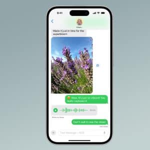 A smartphone displays a text conversation—highlighting Messages vs WhatsApp—with a photo of purple flowers, two green voice messages, and a comment saying, “Wow. It’s just so vibrant! You really captured it.” The Apple logo is in the corner.