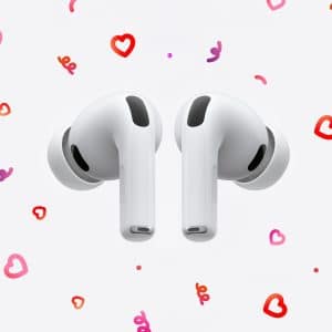 A pair of white wireless earbuds floats on a light background decorated with pink and red hand-drawn hearts, capturing a valentine’s day vibe. The Apple logo appears in the bottom right corner.