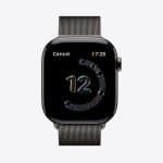 A black Apple Watch with a metallic mesh band features a colorful number "12," a circular Handwashing Timer graphic, the time 7:26, and a "Cancel" option. The Apple logo appears in the bottom right corner.