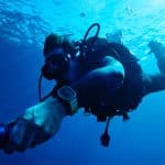Scuba diver wearing Apple Watch Ultra underwater while diving.