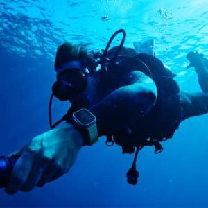 Scuba diver wearing Apple Watch Ultra underwater while diving.