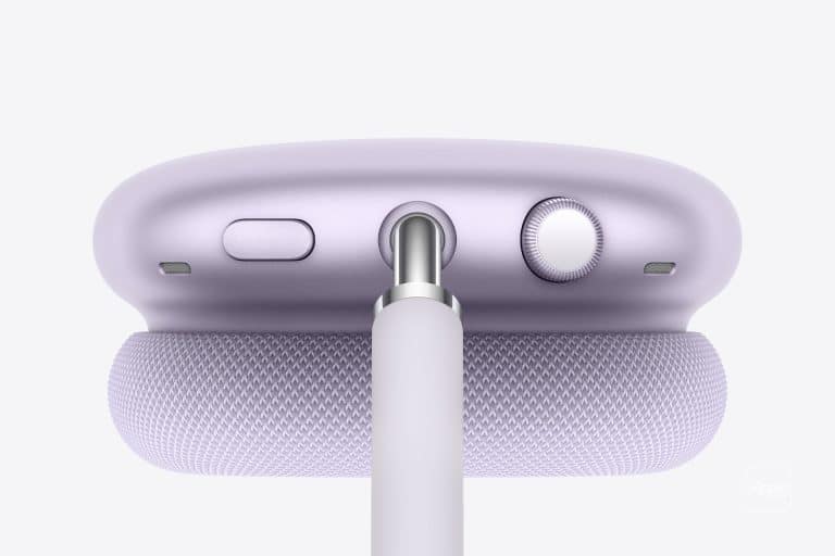 Close-up of a lavender Apple device, likely AirPods Max, showing the top with a mesh headband, buttons, a dial, and a cable plugged into the center port—perfect for tracking charge with AirPods Battery Widgets.