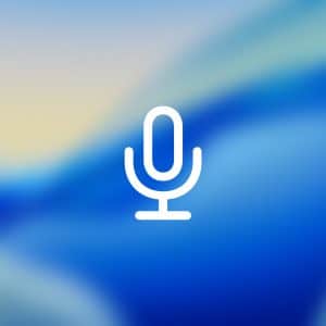 A white microphone icon is centered on a blue and light yellow blurred background, evoking iPhone Keyboard Dictation. In the lower right corner, there is a translucent button with the Apple logo and text.