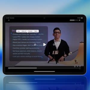 iPhone Live Text - A tablet displays a Life Text Video tutorial with a man standing next to a camera setup. A list of filming tips is visible on the screen. The blue gradient background features an Apple logo in the bottom right corner.