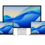 Mac Setup 2026 - Three Apple devices are displayed in a sleek Mac Setup 2026: a large monitor in the center and two MacBook M5 laptops on either side, all showing a blue abstract wave wallpaper. The Apple logo is in the bottom right corner.