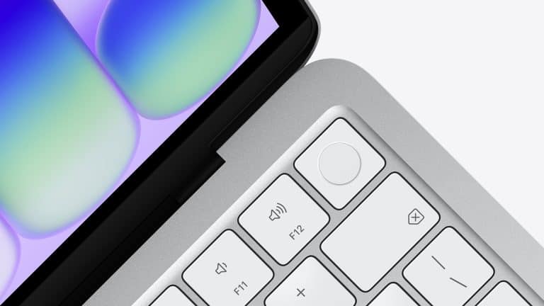 Close-up of a laptop keyboard and part of the display, with white keys, a circular fingerprint sensor button, and a colorful abstract pattern on the screen highlighting MacBook Neo performance.